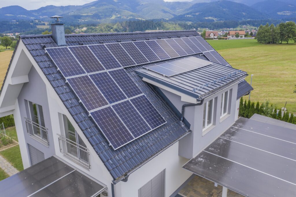 Photo d'une maison dans une prairie avec des panneaux solaires installés sur celle-ci